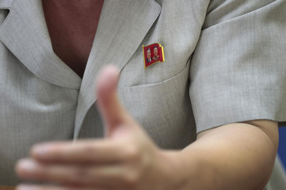 In this Sept. 12, 2019 photo, Kim Chang Kyong, Juche expert and who is also the head of North Korean Social Scientists Association, wears a pin of the late North Korean leaders Kim Il Sung and Kim Jong Il during an interview with Tthe Associated Press in Pyongyang, North Korea. It's just a single word, but it's hard to miss in North Korea: Splashed across countless propaganda signs, seeded through dozens of state media reports, at the beating heart of emotional pop songs and on the lips of the earnest guides who show off the grand monuments built in its honor. The word is Juche, and while it's technically a political ideology, in its difficulty for many outsiders to grasp, its ability to inspire devotion among North Koreans, and its ubiquity as a symbol of state power, it can seem more like a religion. (AP Photo/Dita Alangkara)