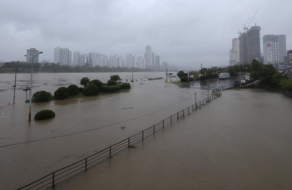 A part of a road and riverside are flooded, caused by the tropical storm named Khanun near the Taehwa River in Ulsan, South Korea, Thursday, Aug. 10, 2023. The strong tropical storm blew ashore in South Korea on Thursday morning, dumping heavy rain and pummeling its southern regions after thousands of people were evacuated. (Kim Yong-tae/Yonhap via AP)