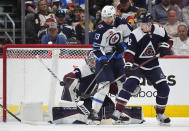 Winnipeg Jets center Gabriel Vilardi, front left, redirects the puck as Colorado Avalanche defenseman Josh Manson, front right, and goaltender Alexandar Georgiev cover in the first period of an NHL hockey game Saturday, April 13, 2024, in Denver. (AP Photo/David Zalubowski)