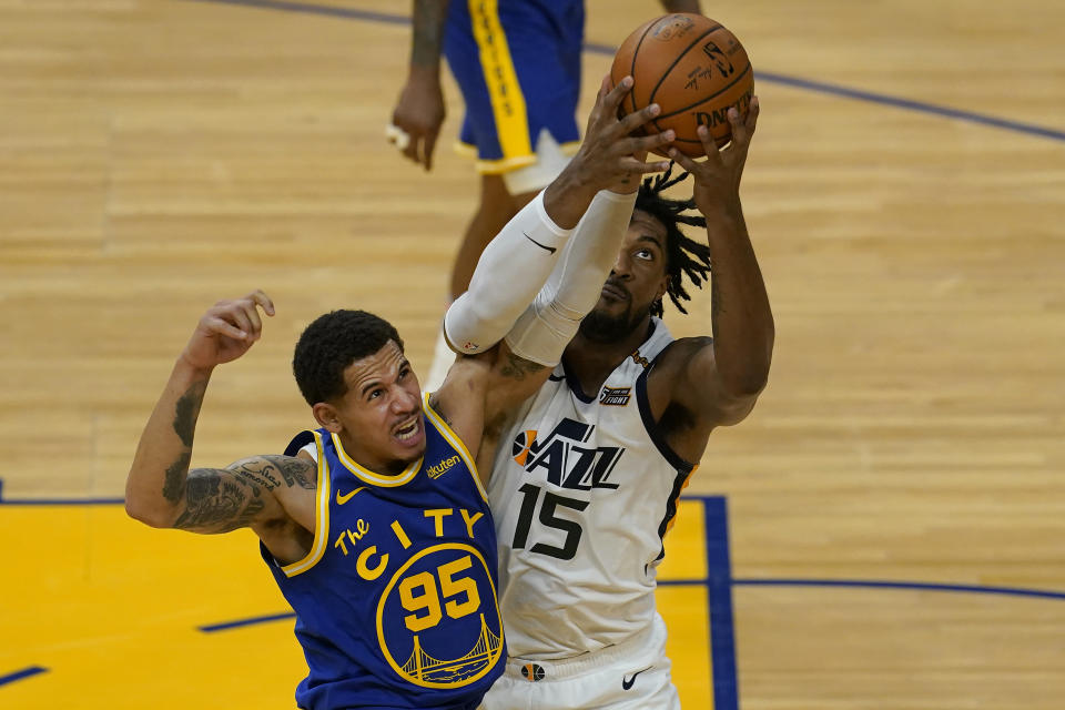 Golden State Warriors forward Juan Toscano-Anderson (95) reaches for the ball next to Utah Jazz center Derrick Favors (15) during the first half of an NBA basketball game in San Francisco, Monday, May 10, 2021. (AP Photo/Jeff Chiu)