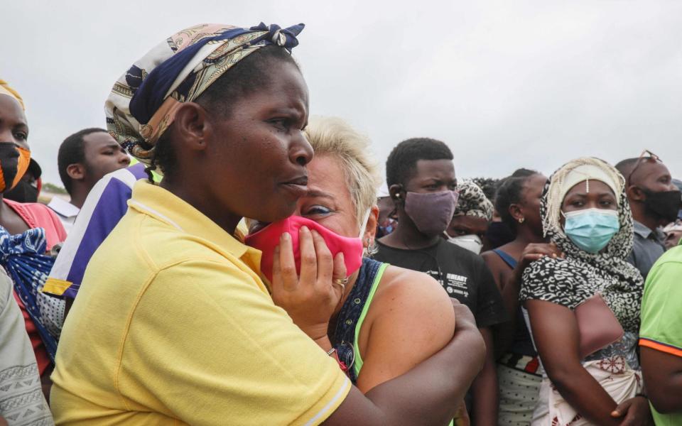 A woman waits for her son to arrive in Pemba on April 1, from the boat of evacuees from the coasts of Palma - Alfredo Zuniga/AFP