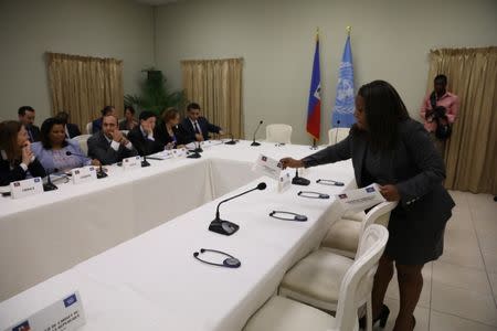 A woman place cards as members of the Security Council of United Nations await for the arrival of Haitian president, Jovenel Moise, and his cabinet, in the National Palace of Port-au-Prince, Haiti, June 22, 2017. REUTERS/Andres Martinez Casares