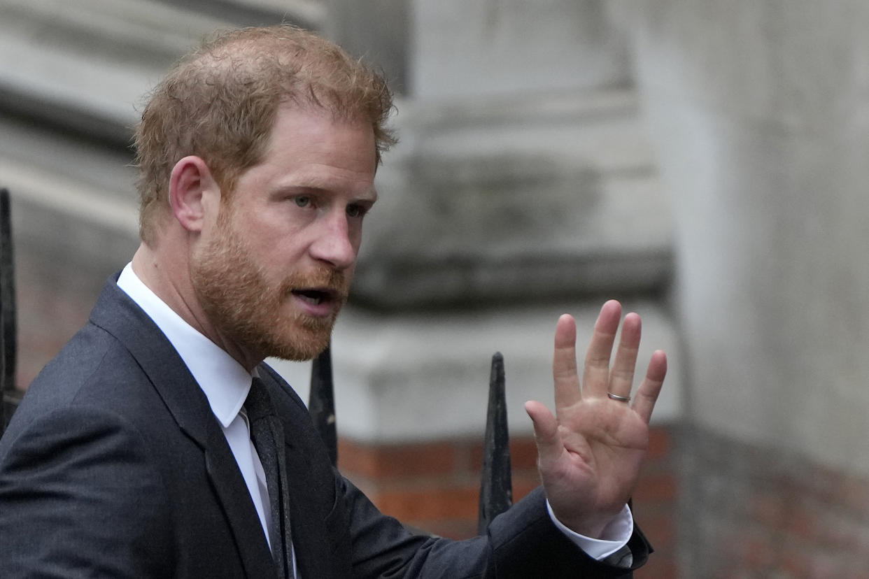 Britain's Prince Harry waves to the media as he arrives at the Royal Courts Of Justice in London, Tuesday, March 28, 2023. Prince Harry is in a London court on Tuesday as the lawyer for a group of British tabloids prepared to ask a judge to toss out lawsuits by the prince, Elton John and several other celebrities who allege phone tapping and other invasions of privacy.(AP Photo/Alastair Grant)