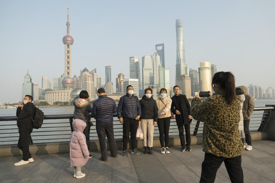 Visitors wearing protective face masks pose for a photo along the Bund in Shanghai, Thursday, Jan. 30, 2020. China counted 170 deaths from a new virus Thursday and more countries reported infections, including some spread locally, as foreign evacuees from China's worst-hit region returned home to medical observation and even isolation. (AP Photo)