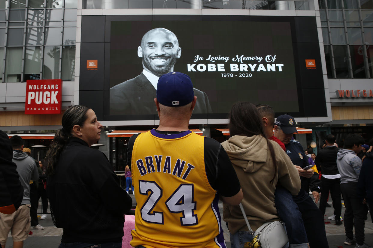 Mourners look at an image of Kobe Bryant on a large screen outside the Staples Center after the retired Los Angeles Lakers basketball star was killed in a helicopter crash, in Los Angeles, California, U.S. January 26, 2020. REUTERS/Monica Almeida