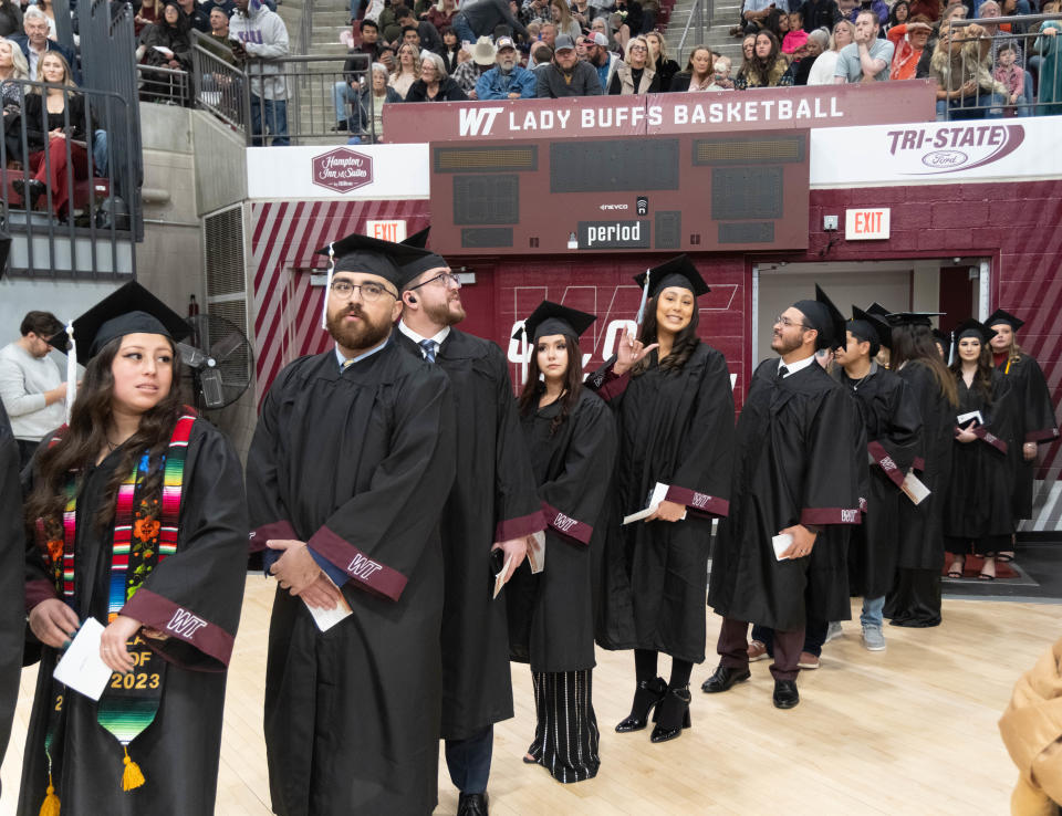 A graduating student gives the WT buffalo gesture to her family at the WT commencement ceremony Saturday morning at the First United Bank Center in Canyon.