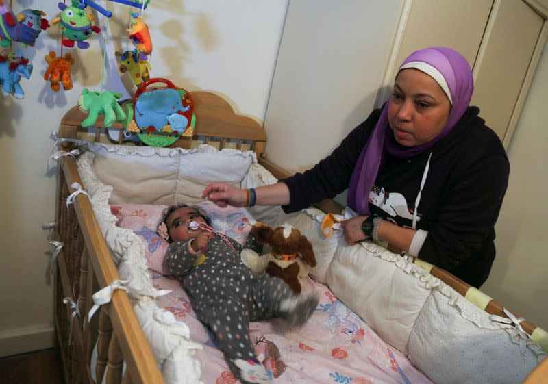 Yasmina al-Habbal, sits next to her Ghlaya, an orphan she sponsors, at her home in Cairo