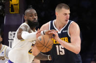 Los Angeles Lakers forward LeBron James, left, knocks the ball from the hands of Denver Nuggets center Nikola Jokic during the second half in Game 4 of an NBA basketball first-round playoff series Saturday, April 27, 2024, in Los Angeles. (AP Photo/Mark J. Terrill)