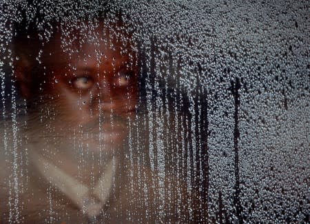 FILE PHOTO: A suspected Ebola patient stands behind a plastic screen at an Ebola treatment centre in Butembo