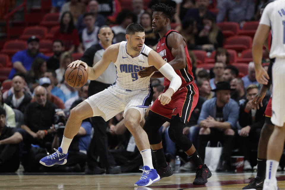 Orlando Magic center Nikola Vucevic (9) drives up against Miami Heat forward Jimmy Butler during the first half of an NBA basketball game Wednesday, March 4, 2020, in Miami. (AP Photo/Wilfredo Lee)