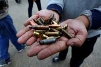 Man shows the casings from bullets which were allegedly used against protesters who were killed at an anti-government protest overnight in Najaf