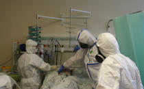 Health care workers prepare to transport a COVID-19 patient from an intensive care unit (ICU) at hospital in Kyjov to hospital in Brno, Czech Republic, Thursday, Oct. 22, 2020. Coronavirus infections in the Czech Republic are on a steep rise, setting a new record high for the second straight day. About 4,500 COVID-19 patients have filled up the country's hospital with the government expected the health system will be overwhelmed by Nov 11 if the surge doesn't slow. (AP Photo/Petr David Josek)