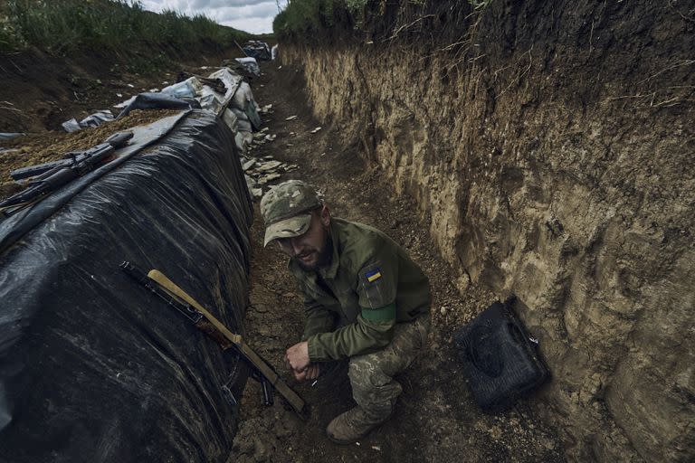 Un soldado ucraniano se sienta en una trinchera en el frente cerca de Bakhmut, en la región de Donetsk, Ucrania, el lunes 22 de mayo de 2023. (AP Foto/Libkos)