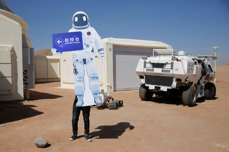 A staff member sets up a sign in the shape of a space suit at the C-Space Project Mars simulation base in the Gobi Desert outside Jinchang, Gansu Province, China, April 17, 2019. REUTERS/Thomas Peter