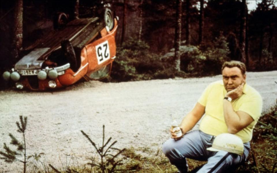 Erik Carlsson next to his crashed Saab 96 rally car