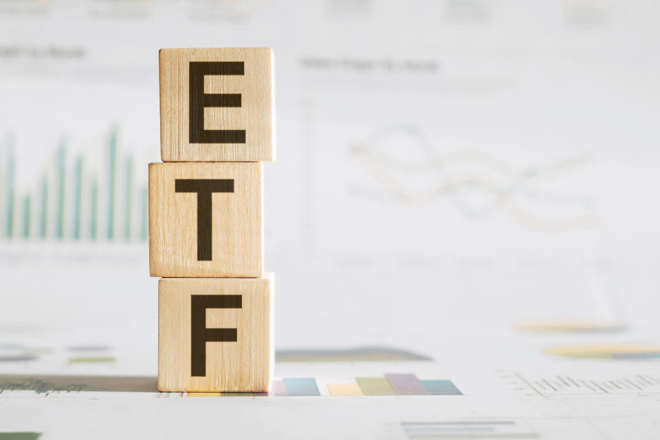 ETF word written on wood block on chart background .