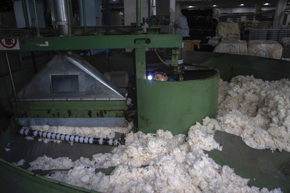 A worker performs maintenance work on a machinery at the Wenzhou Tiancheng Textile Company, one of China's largest cotton recycling plants in Wenzhou in eastern China's Zhejiang province on March 20, 2024. (AP Photo/Ng Han Guan)