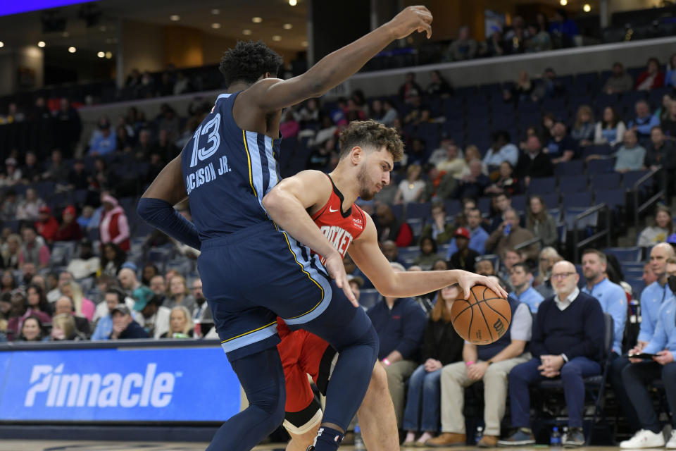 Houston Rockets center Alperen Sengun is defended by Memphis Grizzlies forward Jaren Jackson Jr. (13) during the first half of an NBA basketball game Wednesday, Feb. 14, 2024, in Memphis, Tenn. (AP Photo/Brandon Dill)