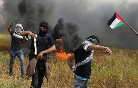 A Palestinian demonstrator holds an axe during clashes with Israeli troops, during a tent city protest along the Israel border with Gaza, demanding the right to return to their homeland, the southern Gaza Strip March 30, 2018. REUTERS/Ibraheem Abu Mustafa