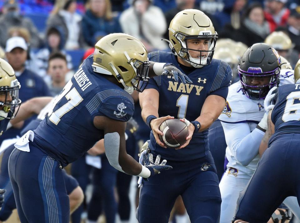 Navy quarterback Tai Lavatai hands off to James Harris II during the first quarter against East Carolina in an NCAA college football game Saturday, Nov. 20, 2021, in Annapolis, Md. (Paul W. Gillespie/The Baltimore Sun via AP)