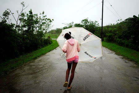 Dalma Samora, 14, walks against the winds of Subtropical Storm Alberto as it passes by the west coast of Cuba, in La Palma, Cuba, May 26, 2018. REUTERS/Alexandre Meneghini