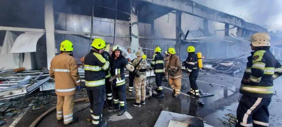 Des pompiers ukrainiens tentent d'éteindre le feu déclenché suite à une frappe sur le centre commercial de Krementchouk dans le centre de l'Ukraine, le 27 juin 2022 - STR / UKRAINE EMERGENCY MINISTRY PRESS SERVICE