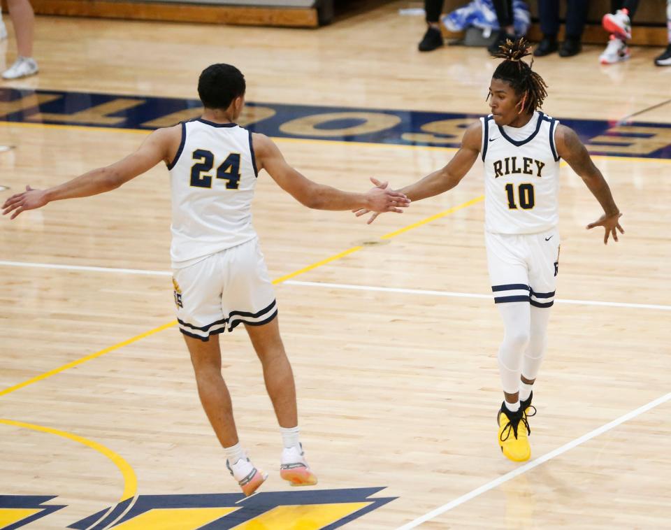 South Bend Riley senior Mancell Hill (24) and junior Marvin Schindler (10) celebrate after Schindler made a '3' during a game against Mishawaka Marian Friday, Dec. 1, 2023, at Riley High School in South Bend.