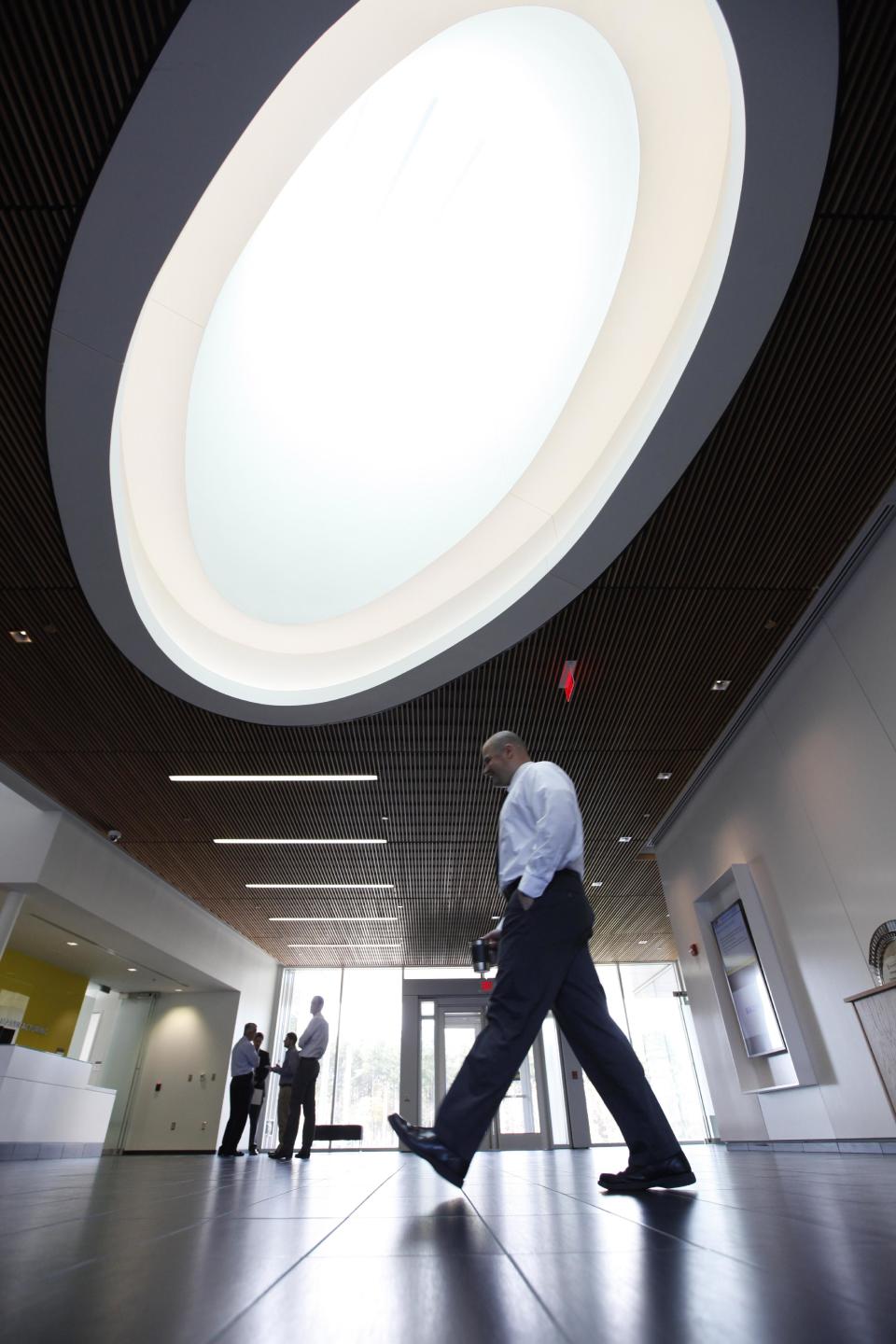 In this Monday, Nov. 12, 2012, photo, a worker walks under the skylight in the lobby of the Commonwealth Center for Advanced Manufacturing, in Prince George, Va. The Commonwealth Center for Advanced Manufacturing is conducting research for a group of manufacturing companies under a partnership with Virginia Tech, Virginia State University and the University of Virginia. (AP Photo/Steve Helber)