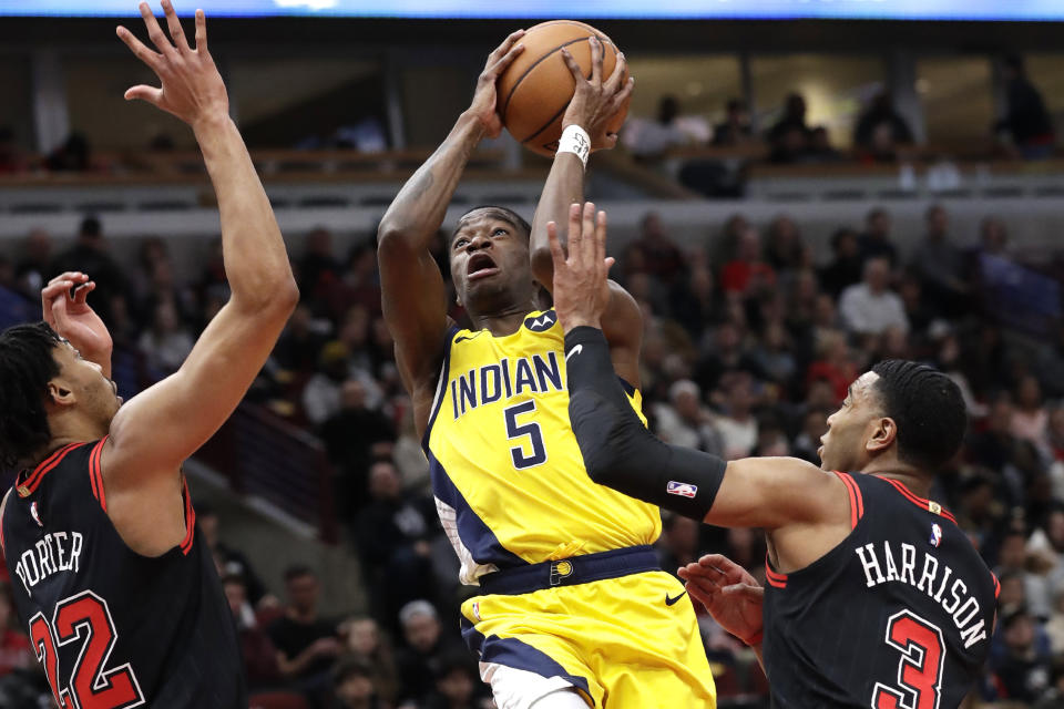 Indiana Pacers guard Edmond Sumner, center, drives to the basket against Chicago Bulls forward Otto Porter Jr., left, and guard Shaquille Harrison during the first half of an NBA basketball game in Chicago, Friday, March 6, 2020. (AP Photo/Nam Y. Huh)