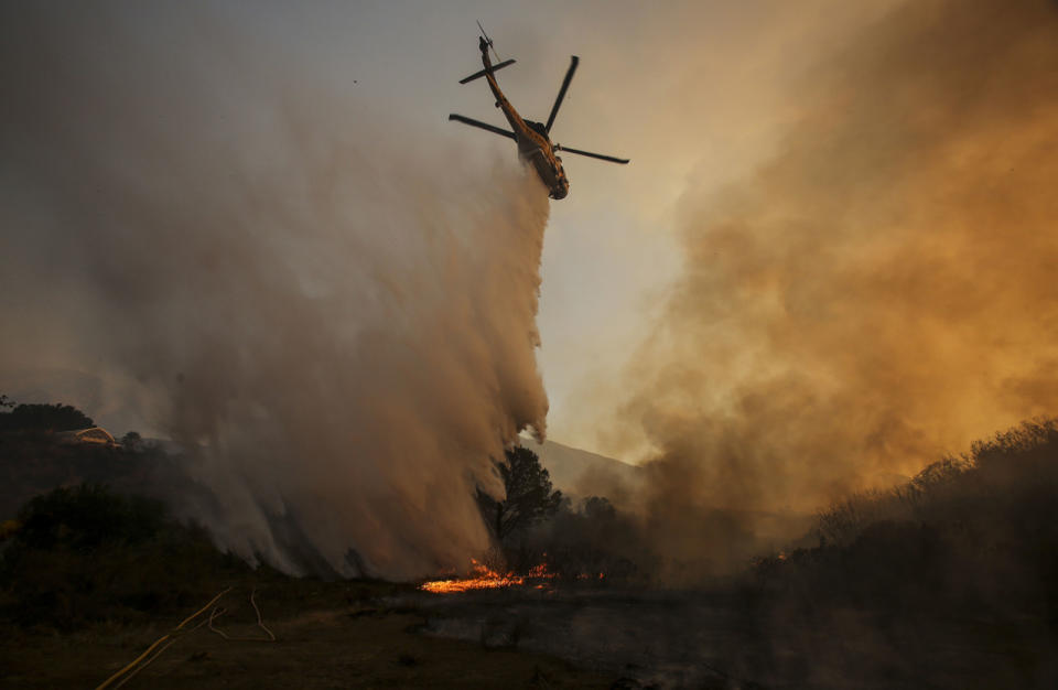 <p>A helicopter makes a drop on a wildfire near Placenta Caynon Road in Santa Clarita, Calif., July 24, 2016. (AP Photo/Ringo H.W. Chiu)</p>