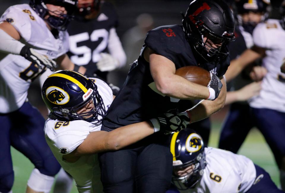 DeWitt's Matthew Nehf, left, stops Linden's Bryce Eliuk, Friday, Nov. 11, 2022, at Linden High School. DeWitt won 29-16.