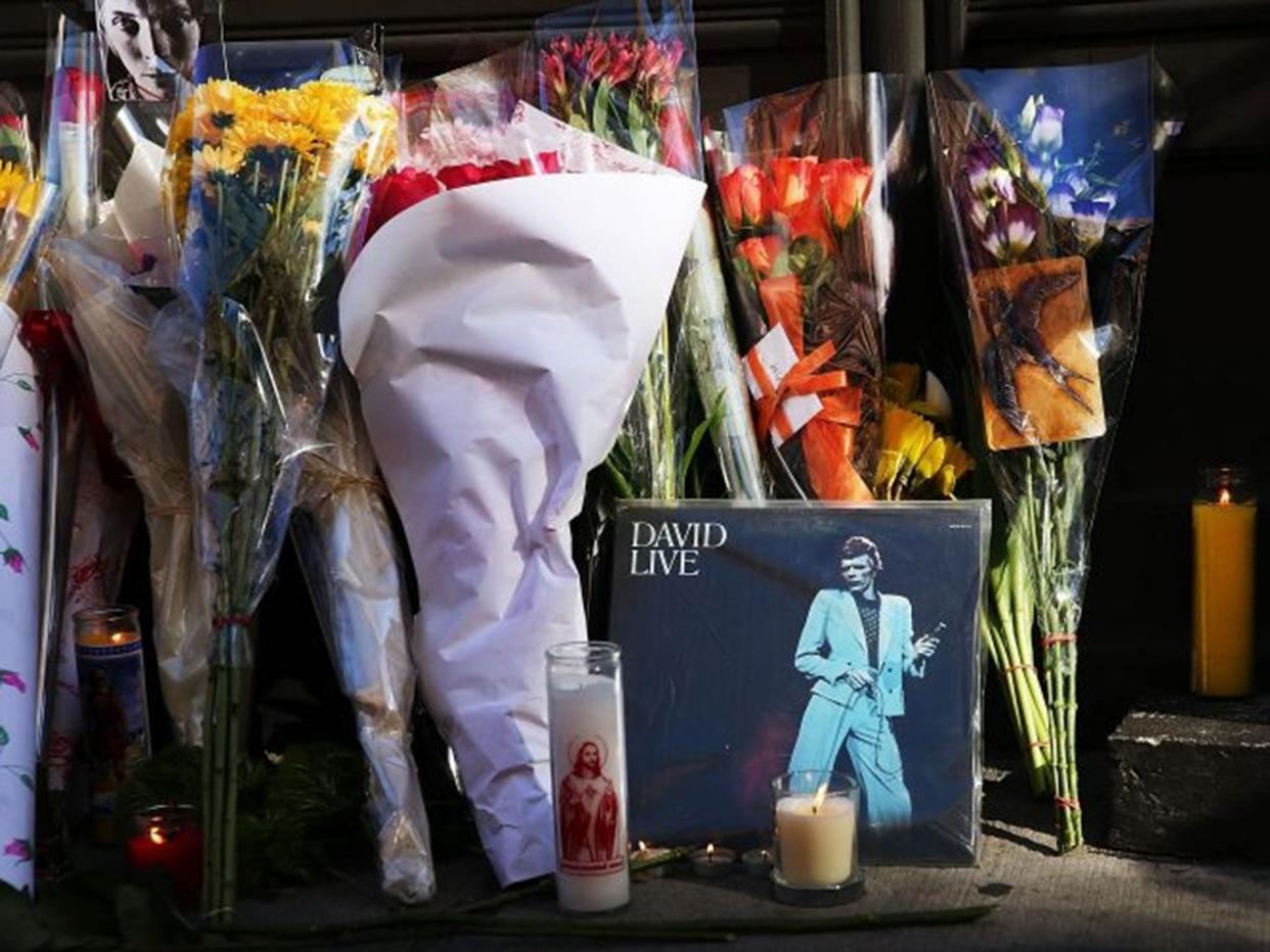 Flowers, candles and pictures are some of the items deposited at a memorial outside of the late musician and performer David Bowie's apartment that he shared with his wife in New York City (Spencer Platt/Getty Images)