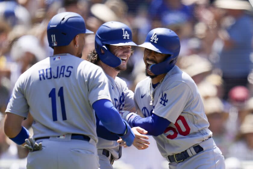 Los Angeles Dodgers' Mookie Betts, right, celebrates with teammates James Outman, center.