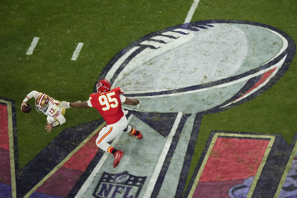 San Francisco 49ers quarterback Brock Purdy, left, evades the pressure by Kansas City Chiefs defensive tackle Chris Jones during the second half of the NFL Super Bowl 58 football game Sunday, Feb. 11, 2024, in Las Vegas. (AP Photo/David J. Phillip)