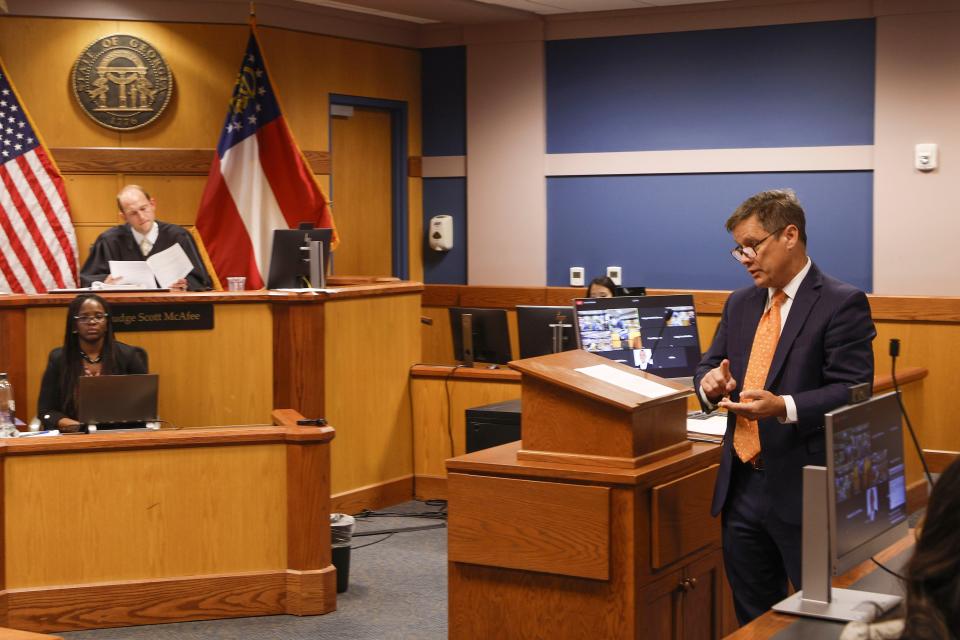 Brian Rafferty, right, attorney for Sidney Powell, gestures as he addresses the court during a motions hearing in front of Fulton County Superior Court Judge Scott McAfee, top left, in Atlanta, Thursday, Oct. 5, 2023. Nineteen people, including former President Donald Trump, were indicted in August and accused of participating in a wide-ranging illegal scheme to overturn the results of the 2020 presidential election. (Erik S. Lesser/Pool Photo, via AP)