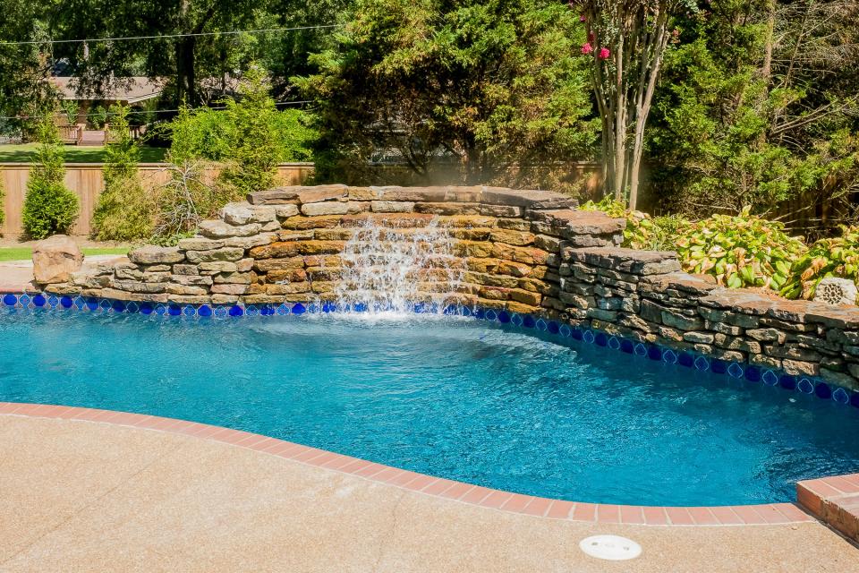 A waterfall sends water cascading into the pool.