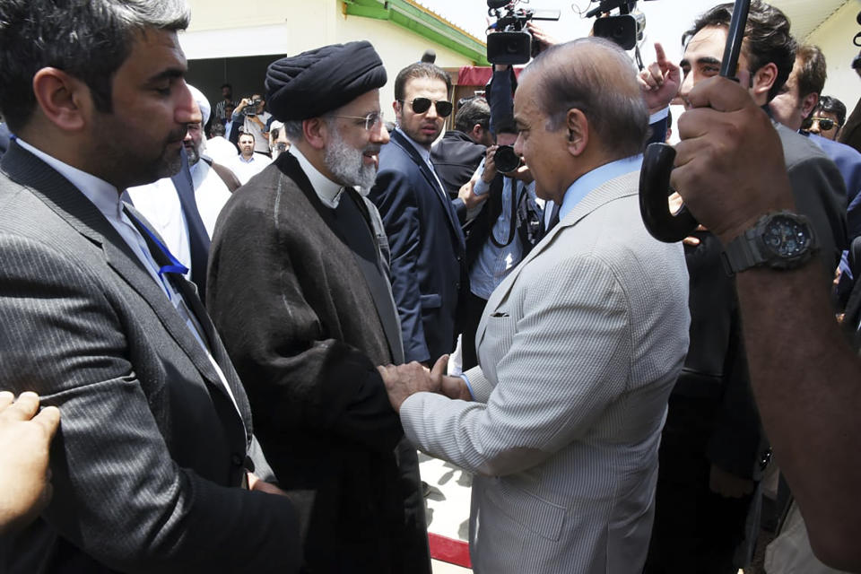 In this photo released by Pakistan Prime Minister's Office, Pakistan's Prime Minister Shahbaz Sharif, right, shakes hand with Iran's President Ebrahim Raisi during an inauguration of the Mand-Pishin border in Pishin, border of Pakistan-Iran, Thursday, May 18, 2023. The leaders of Pakistan and Iran on Thursday jointly inaugurated the much-awaited first border market in the southwest amid warming relations between the two sides to improve bilateral trade and economic ties, officials said. (Pakistan Prime Minister Office via AP)