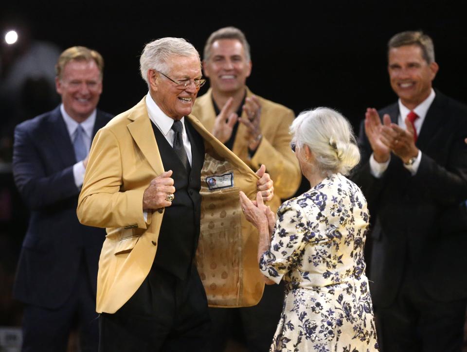 Dick Vermeil, left, is presented his gold jacket from wife Carol Vermeil, right, during the Gold Jacket Dinner at the Canton Memorial Civic Center in Canton on Friday, August 5, 2022.