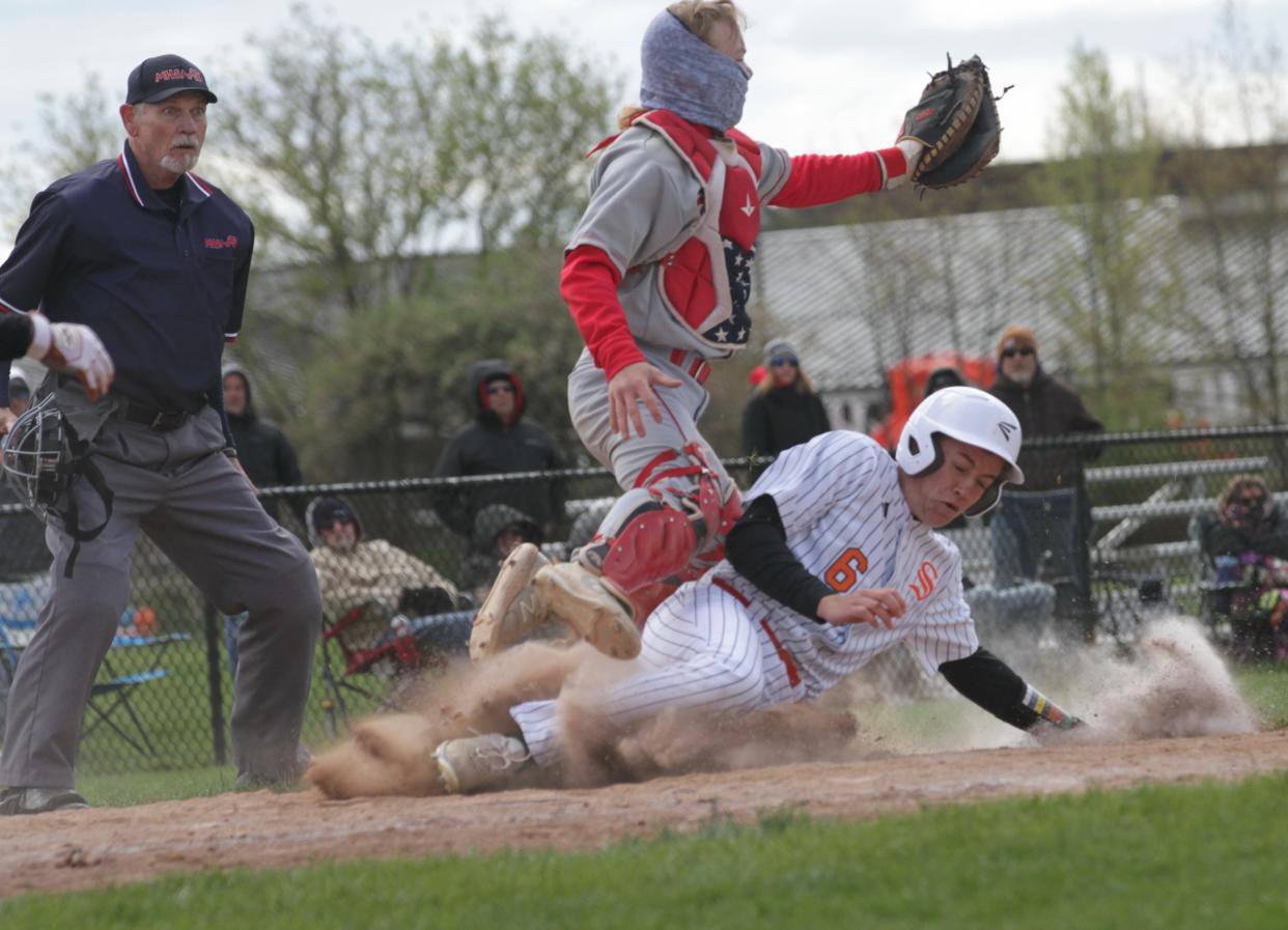 George Bucklin of Sturgis slides safely into home plate to score a run for the Trojans on Saturday.