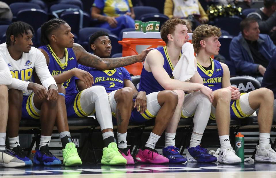 Delaware's Jyare Davis pats fellow starter Christian Ray as he waits out the final moments of the game with Wes Peterson Jr. (left), Jalun Trent (2) and Cavan Reilly in Delaware's 73-58 loss to Hofstra in the quarterfinals of the Coastal Athletic Association tournament, Sunday, March 10, 2024 at the Entertainment and Sports Arena in Washington, DC.