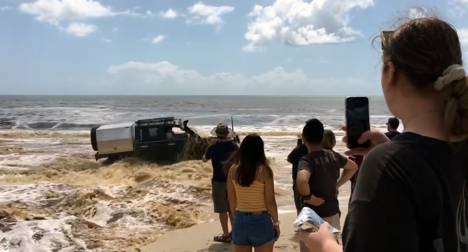 Onlookers pictured recording the incident on Bribie Island.