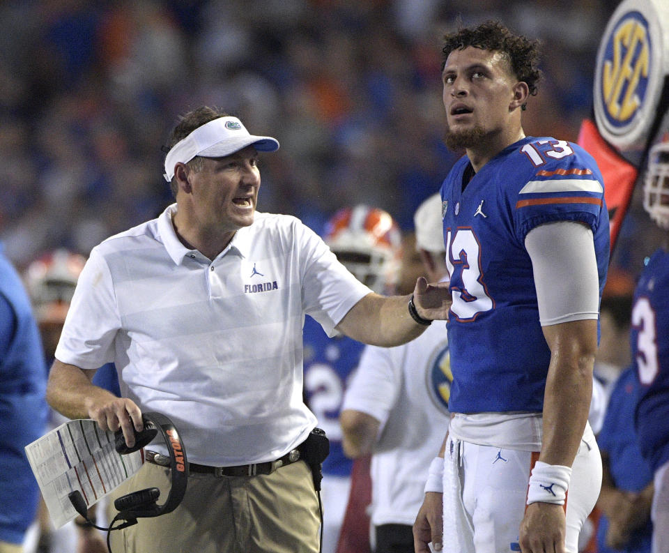 Florida head coach Dan Mullen, left, talks with quarterback Feleipe Franks (13) during a 2018 college football game. (AP)