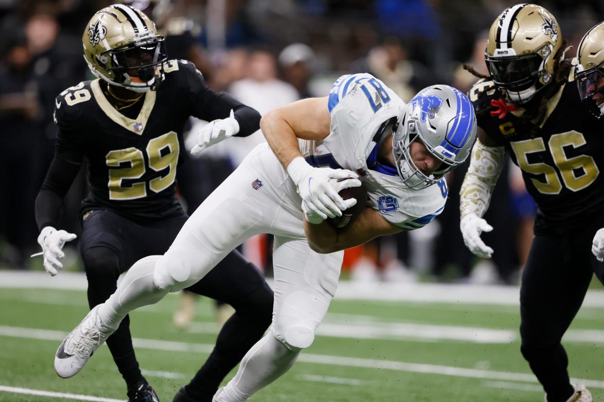 Lions tight end Sam LaPorta catches a pass as Saints cornerback Paulson Adebo, left, and linebacker Demario Davis defend during the second half of the Lions' 33-28 win on Sunday, Dec. 3, 2023, in New Orleans.
