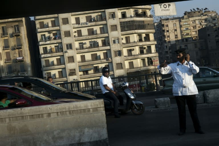 People watch as a motorcade with US Secretary of State John Kerry passes on August 1, 2015 in the Egyptian capital Cairo