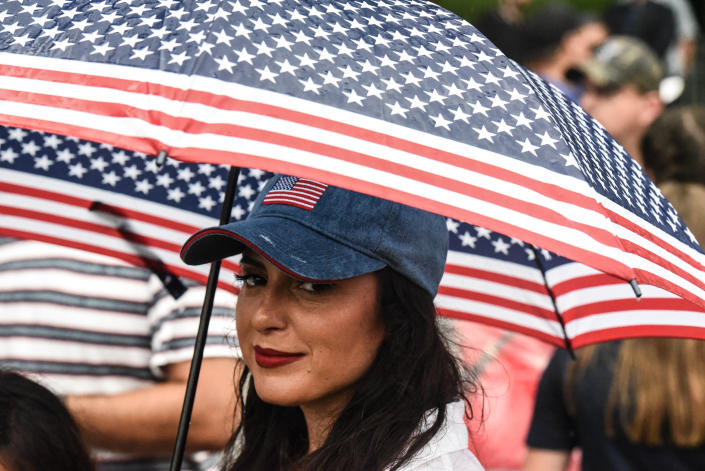  A woman with a red, white and blue umbrella is seen on the National Mall while President Donald Trump gives his speech during Fourth of July festivities on July 4, 2019 in Washington, DC.  (Photo: Stephanie Keith/Getty Images)