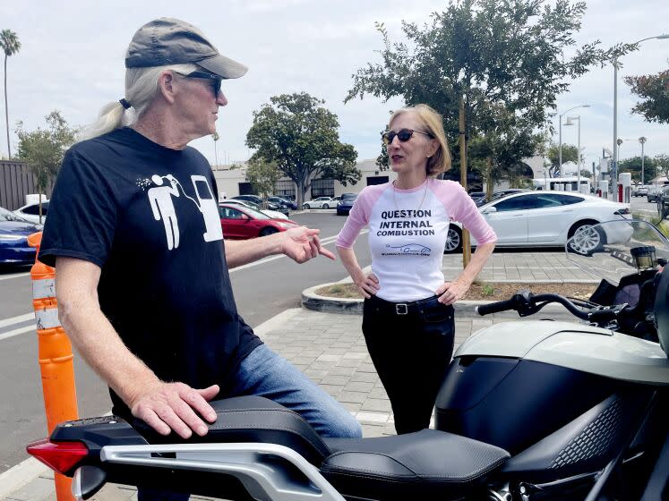 Paul Scott, co-founder of Plug-In America, chats with his ex-wife Zan Dubin-Scott at a Tesla charging station, 14th and Santa Monica Blvd. Paul owns a Tesla but rents it out. His daily vehicle is an electric Zero motorcycle. Zan drives a Chevy Volt.