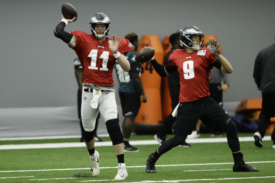 Philadelphia Eagles quarterbacks Carson Wentz (11) and Nick Foles (9) throw passes during NFL football training camp in Philadelphia, Monday, Aug. 13, 2018. (AP Photo/Matt Rourke)