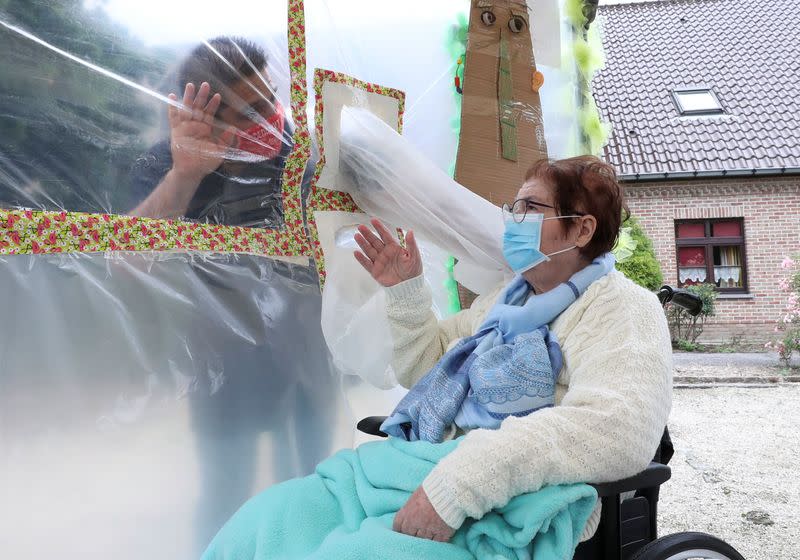 Residents at Belgian nursing home "Le Jardin de Picardie" enjoy hugs and cuddle through a wall made with plastic sheets to protect against potential COVID-19 infection in Peruwelz