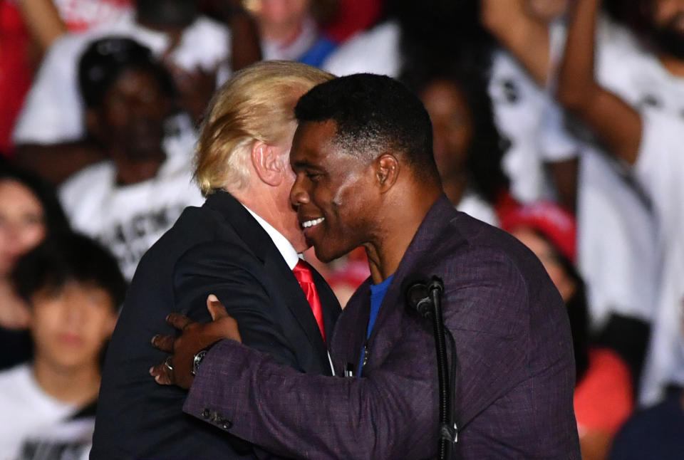 Herschel Walker and Donald Trump embrace onstage.