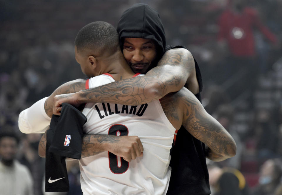 Portland Trail Blazers guard Damian Lillard, foreground, and Los Angeles Lakers forward Carmelo Anthony greet each other before an NBA basketball game in Portland, Ore., Saturday, Nov. 6, 2021. (AP Photo/Steve Dykes)